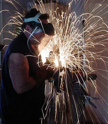 Gilbert McCann grinding a metal sculpture.
